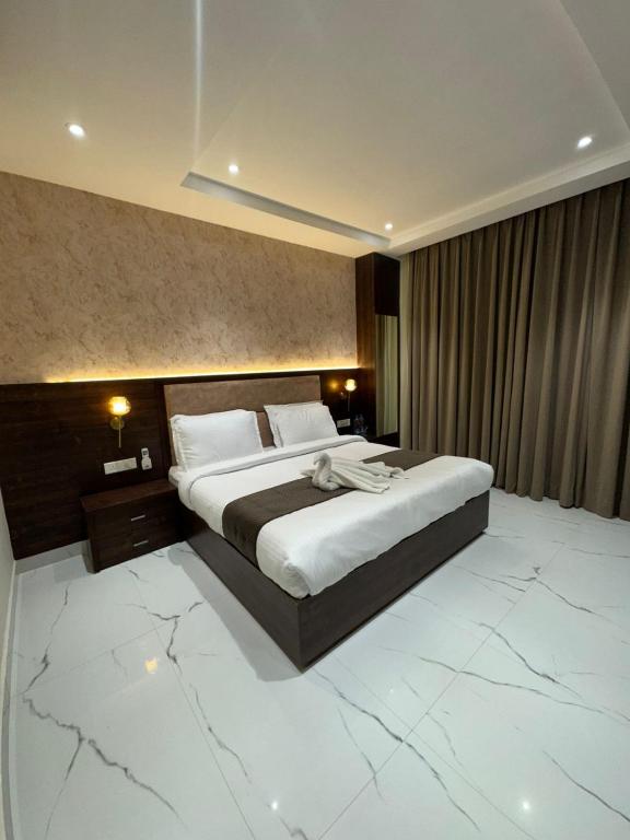 a bedroom with a large bed with a marble floor at Aero Lounge Hotel in Jāmb