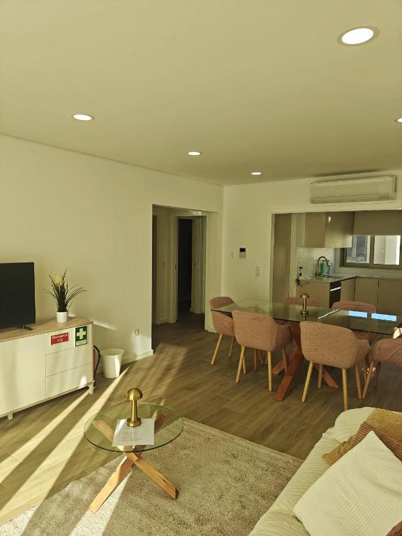 a living room with a table and a kitchen at Refugio do Surf Cortegaça in Cortegaça