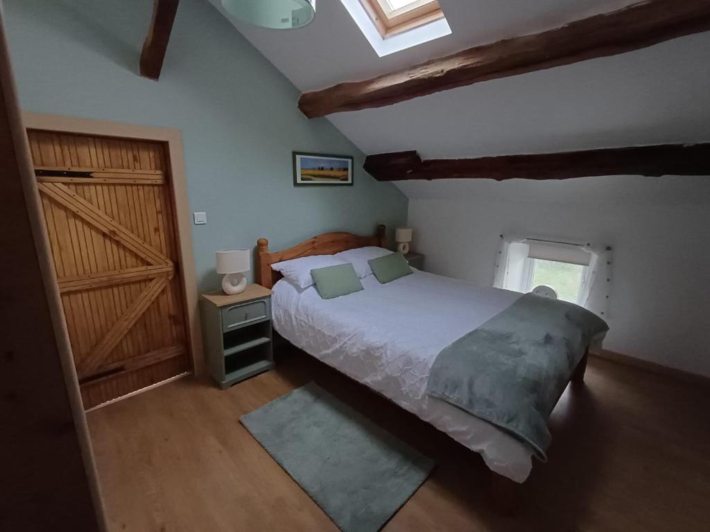 a bedroom with a bed and a wooden door at tillys Cottage in Folles