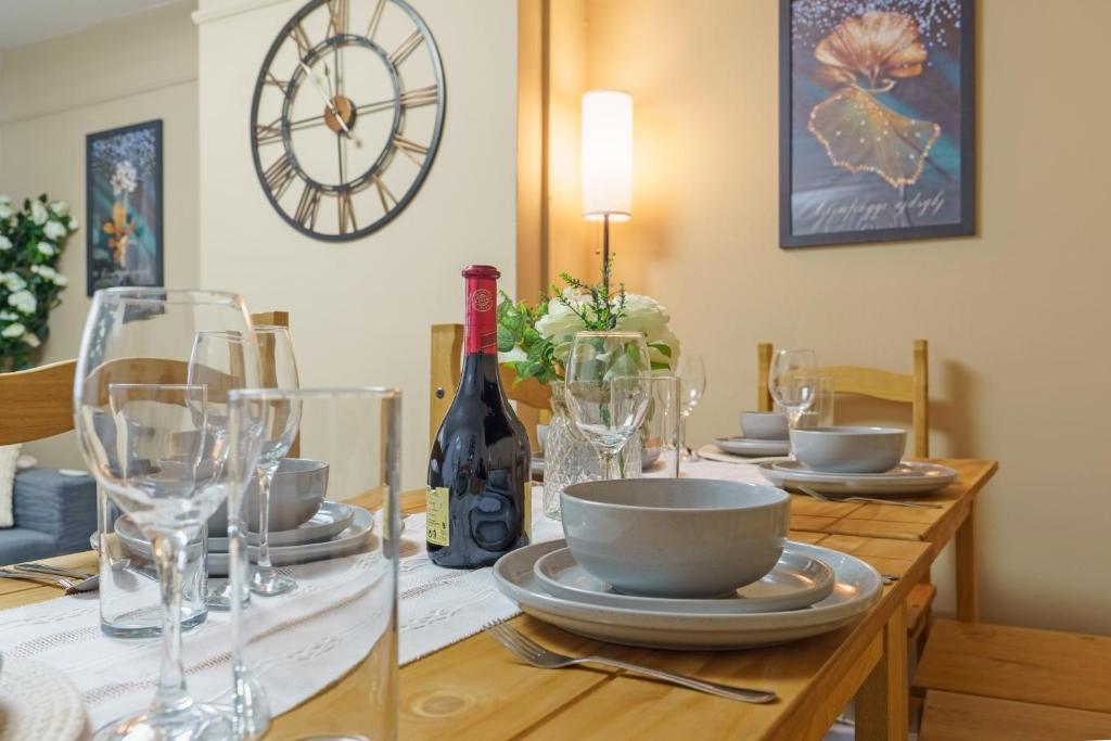 a dining room table with glasses and a bottle of wine at Open Mind Property- Hot Tub, Sleeps 9 & Free Parking in Portsmouth