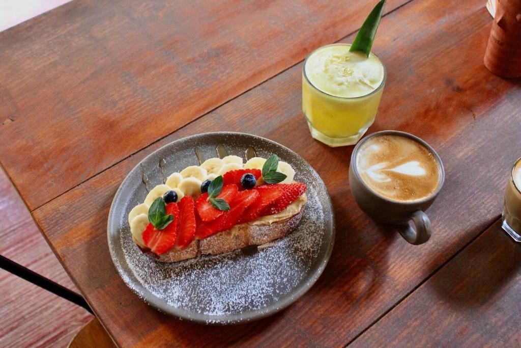 un panino con la frutta su un piatto accanto a una bevanda di Olivo hostel a Puerto Escondido