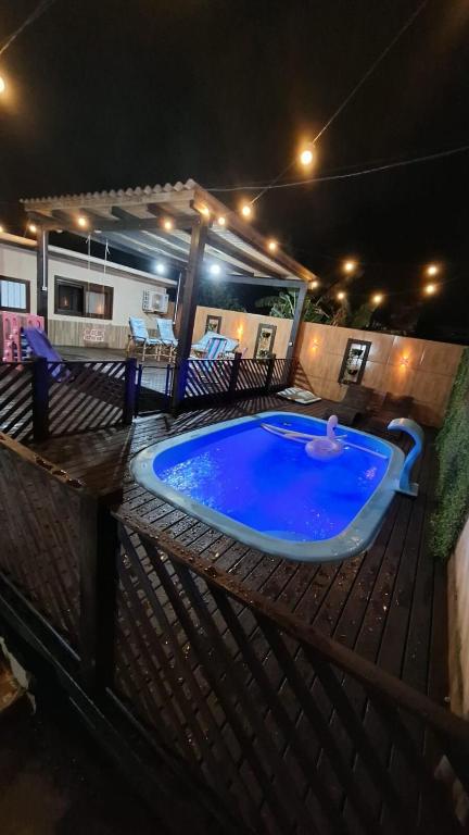 una grande piscina su una terrazza di notte di Casa do Rabelo a Balneário Gaivotas