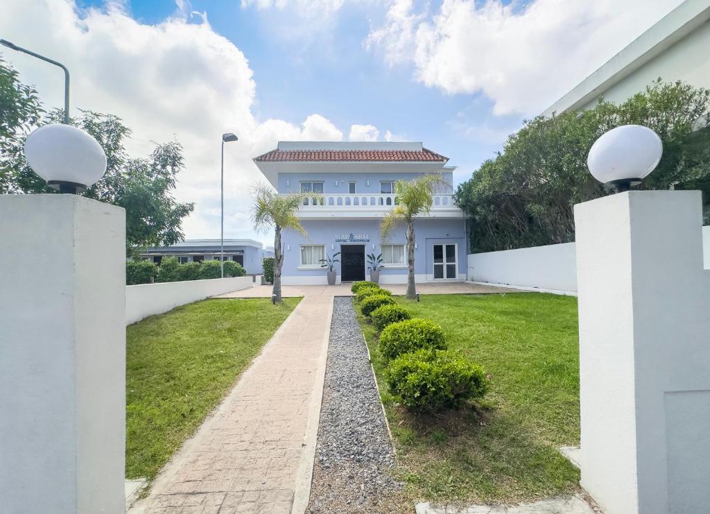 a white house with a pathway at Hotel Mar y Arte in Piriápolis