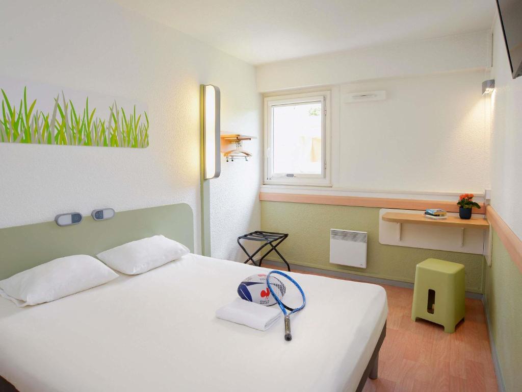 a bedroom with a white bed and a window at ibis budget Toulouse Centre Gare in Toulouse