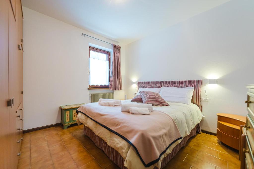 une chambre avec un grand lit avec des serviettes dessus dans l'établissement Sasso Bianco Home - Mountain View & Private Parking, à Sottoguda