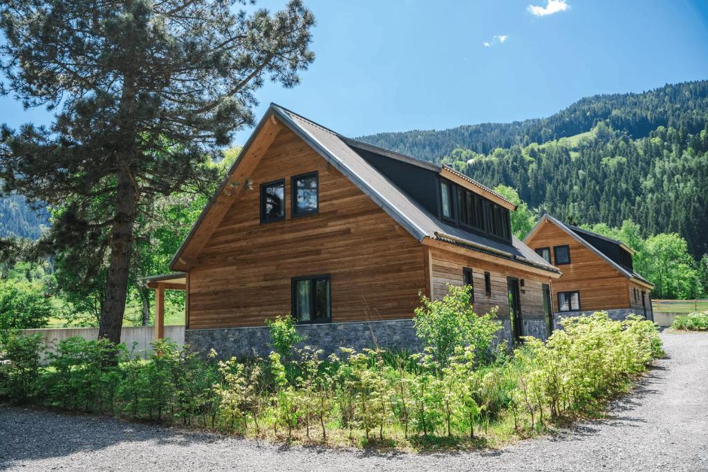 une maison en bois dans les montagnes avec des arbres dans l'établissement Alpenchalet Deluxe Afritz, à Feld am See
