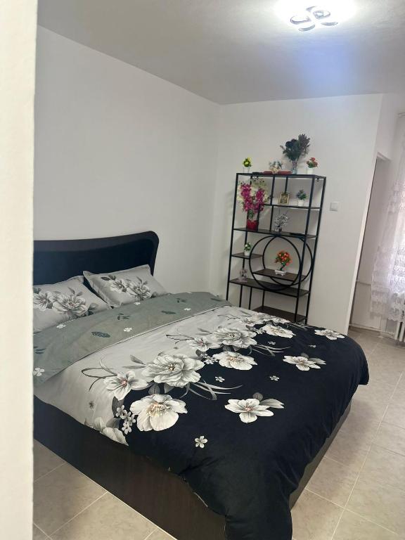een slaapkamer met een bed met een zwarte deken met bloemen bij Studio Relax2 in Bacău