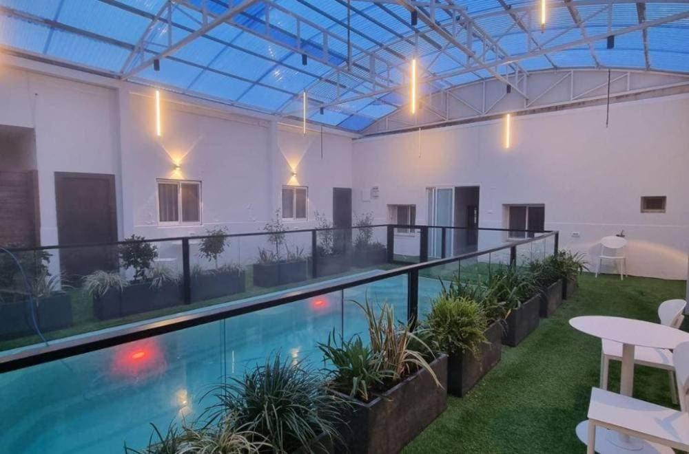 a large swimming pool in a building with a patio at Don Leon Boutique in Even Menahem
