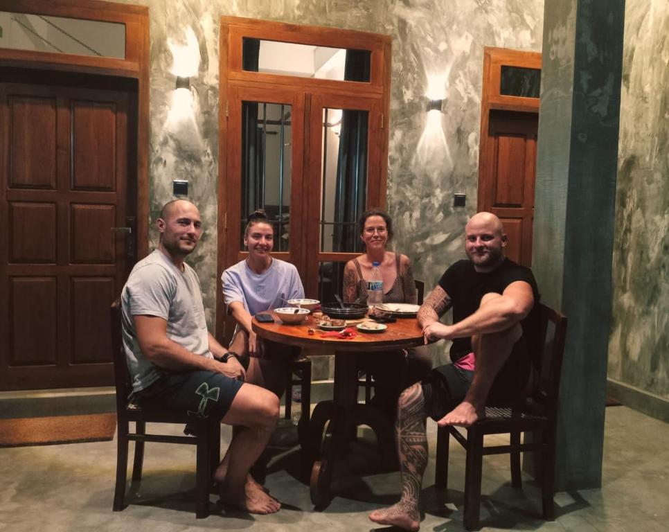 een groep mensen die rond een tafel zitten bij Amandaa Homestay in Dikwella
