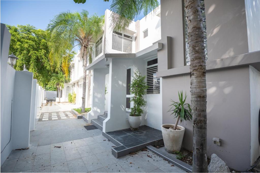 a courtyard of a white building with palm trees at Casa Lotus in San Juan