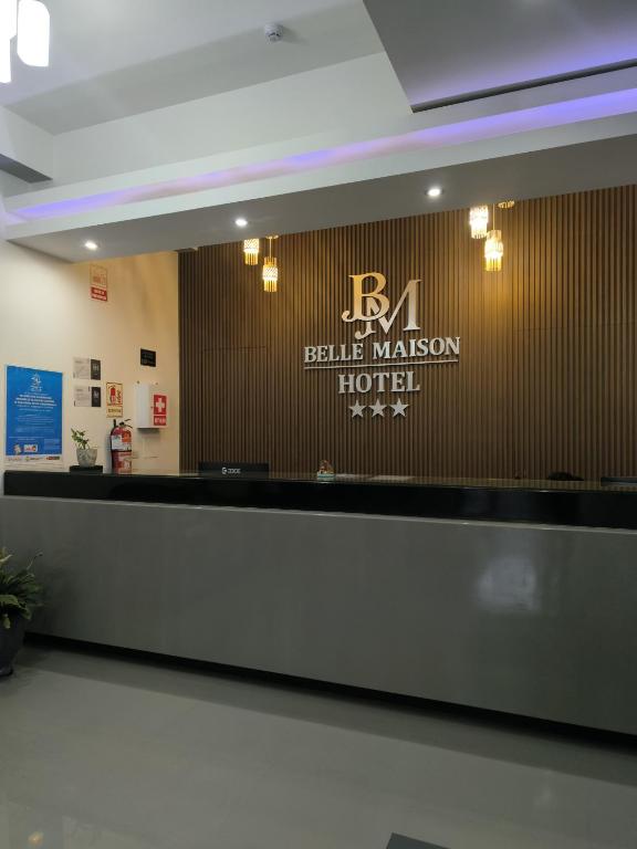 una reception in un hotel con un cartello sul muro di Hotel Belle Maison a Chiclayo