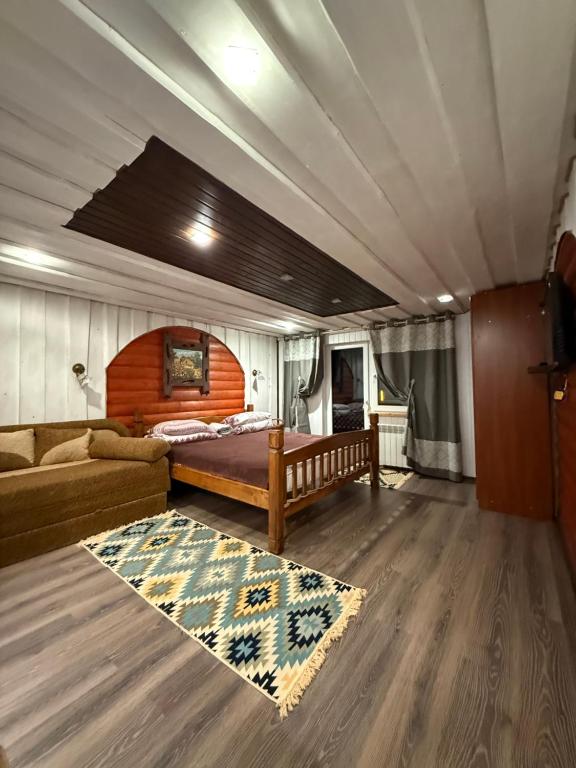 een slaapkamer met een bed en een bank in een kamer bij У Віти номер 4 in Synevyrsʼka Polyana