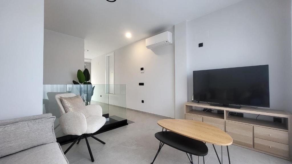 un soggiorno con un divano, una TV e un tavolo di Boulevard Getaway I a Guanarteme