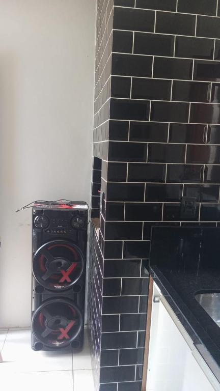 ein Herd in einer Küche mit einer schwarz gefliesten Wand in der Unterkunft Lar Sousa Rocha in Capão da Canoa