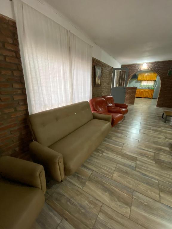 een woonkamer met een bank en rode stoelen bij Casa en complejo in San Roque