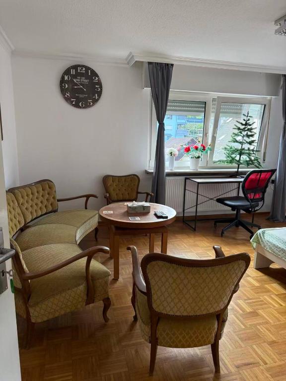een woonkamer met stoelen en een tafel en een klok bij Haus Heigenbrücken in Heigenbrücken