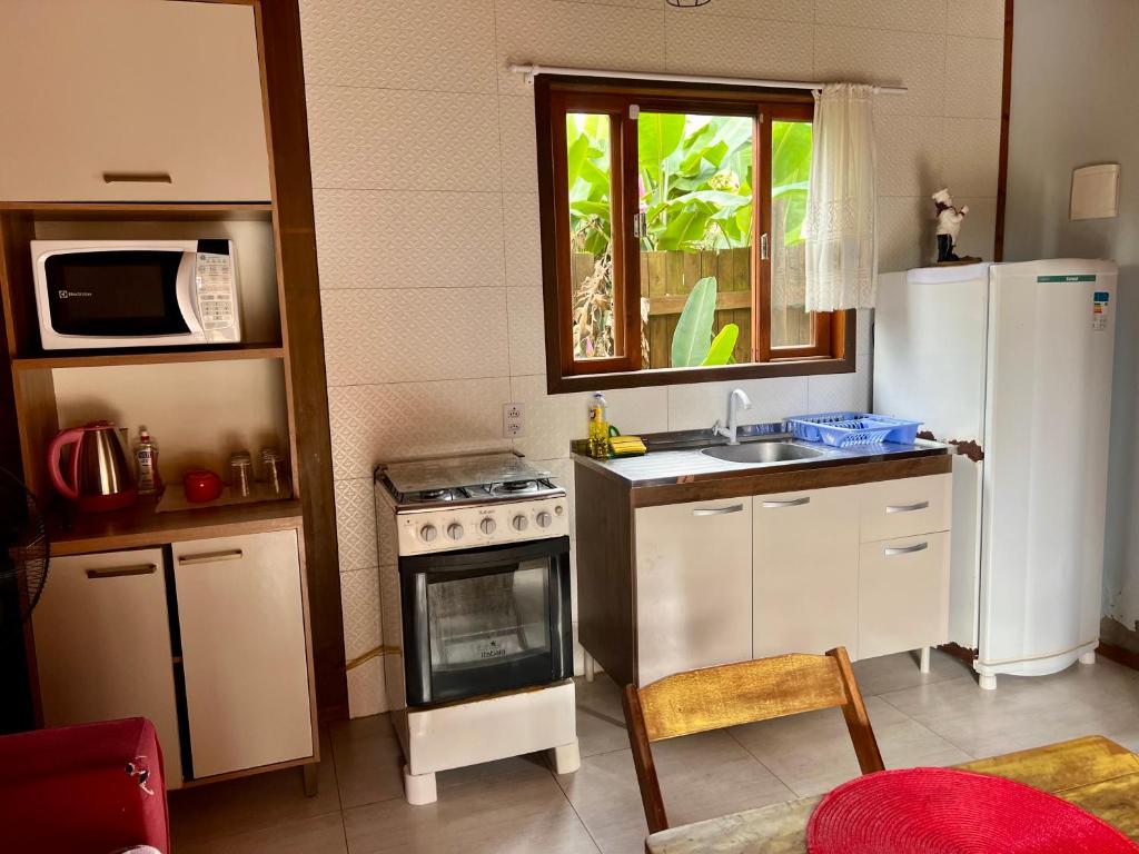 una piccola cucina con frigorifero e lavandino di Rose-mar a Imbituba