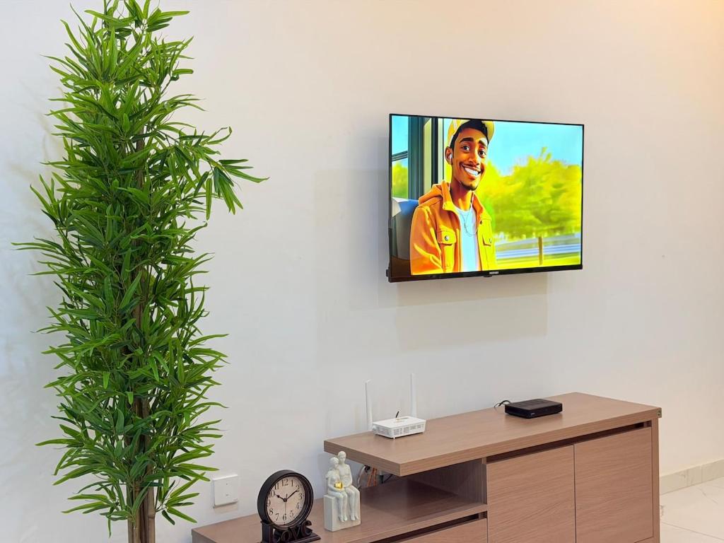 einen TV, der an einer Wand im Wohnzimmer hängt in der Unterkunft A Serene home away from home in Damba