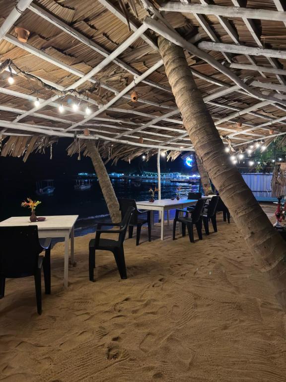 a group of tables and chairs on a beach at Seasong Rooms in Unawatuna