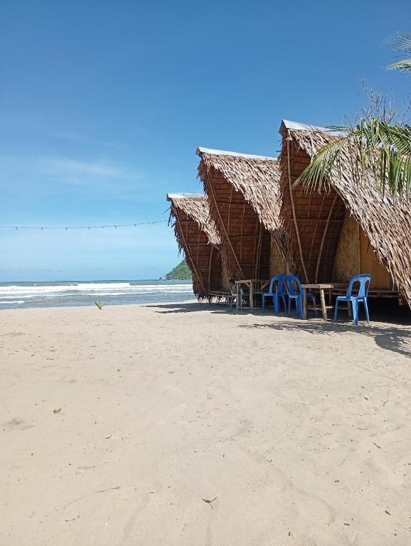 a beach with chairs and umbrellas on the beach at El Hermosa Bice Camp in El Nido