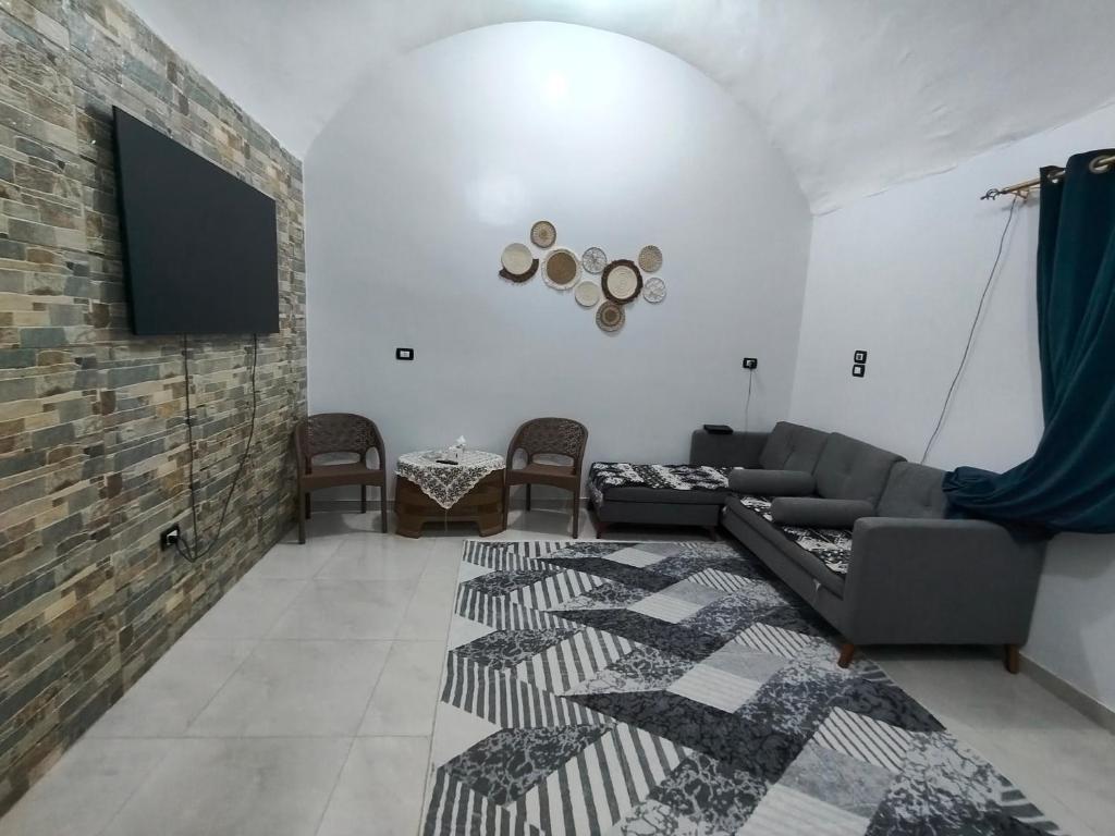 een woonkamer met een bank en een flatscreen-tv bij Sunrise in Abu Simbel