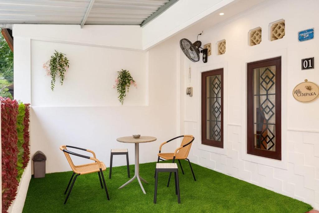una stanza con tavolo e sedie sull'erba di Villa Cempaka - Pemogan a Denpasar