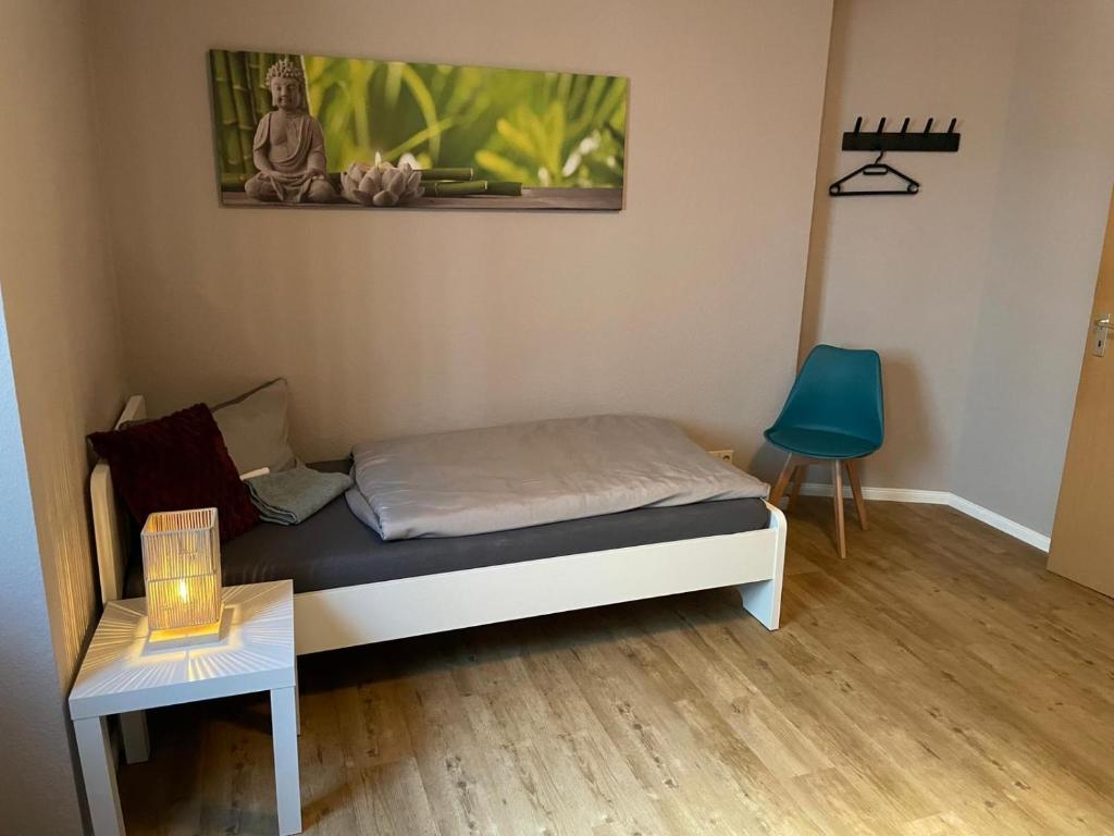 una piccola camera con letto e sedia blu di Cottbus Virchowstraße Zentrum a Cottbus