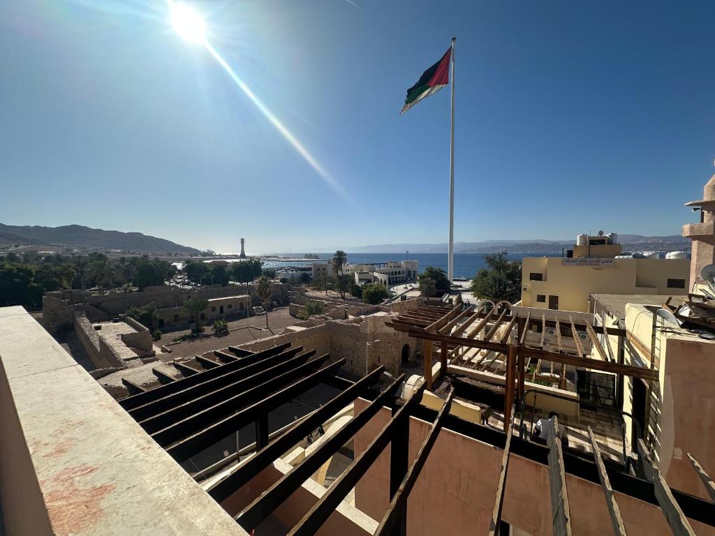 a flag flying on top of a building at Happy Beach Castel for Apartment قلعة شاطئ السعادة للشقق المفروشة in Aqaba