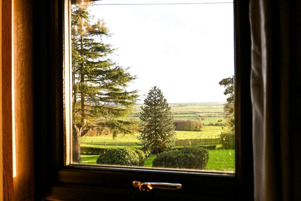 a window with a view of a green field at Piglets Place in Hythe