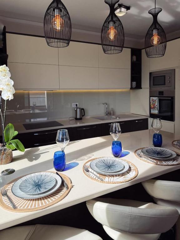 a kitchen with two plates and wine glasses on a counter at Apartment Zoe in Tivat