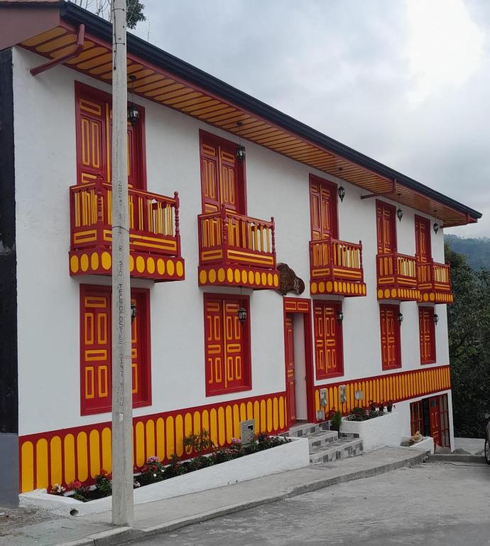 a white building with red and yellow windows at La Casa De Mi Tatis in Salento
