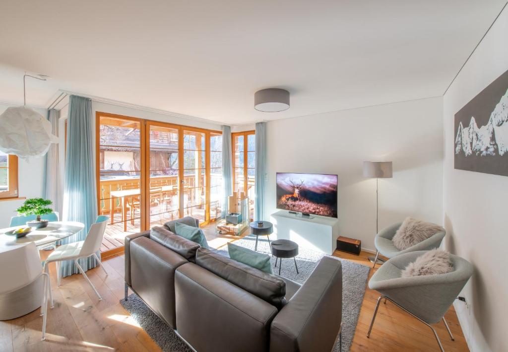 a living room with a couch and a table at Panoramapark Soleil Chalet C in Wengen