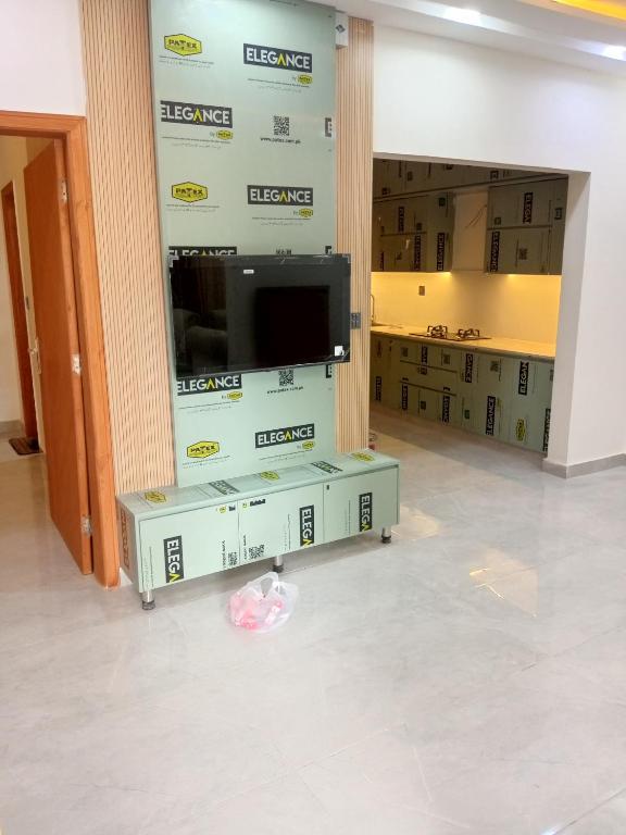 a room with a flat screen tv and boxes at Bahria town karachi Volka Guest House in Karachi
