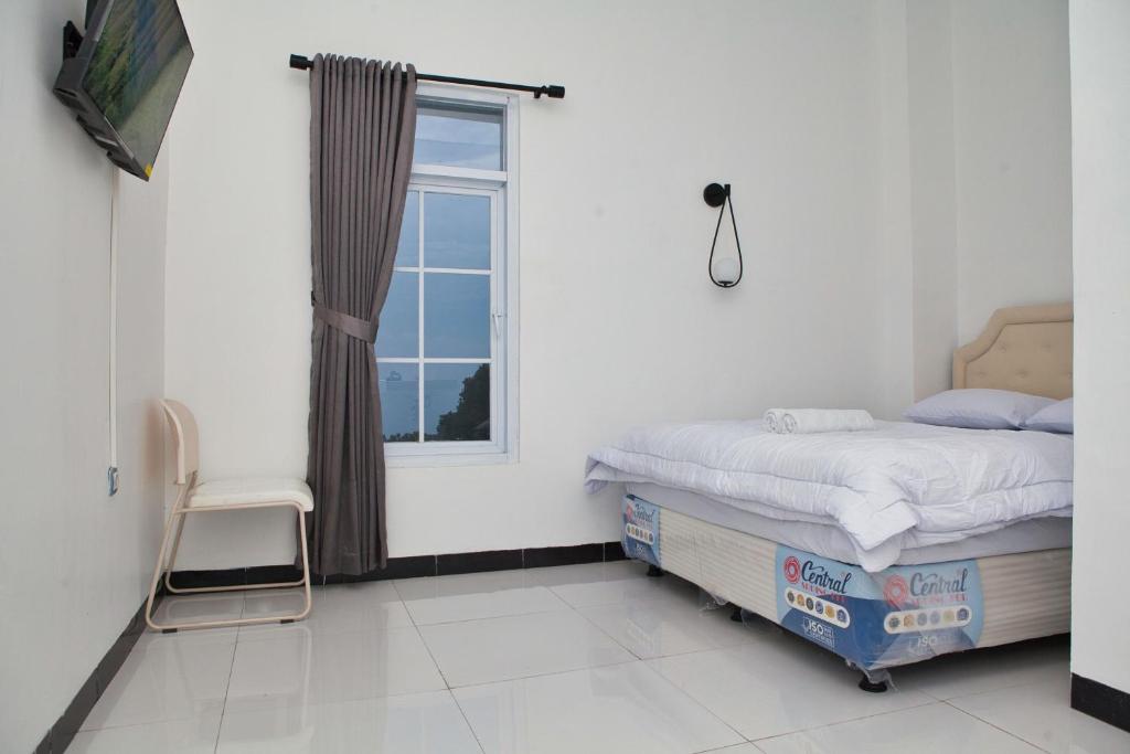 a bedroom with a bed and a window at Clarissa Guest House Cisarua Bandung in Sukaraja