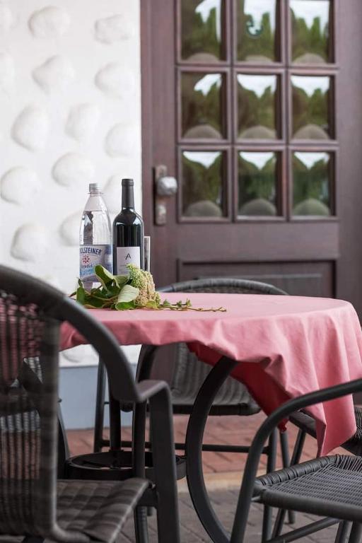 a table with a pink table cloth and two bottles of wine at Ferienwohnung PfalzRide in Annweiler am Trifels