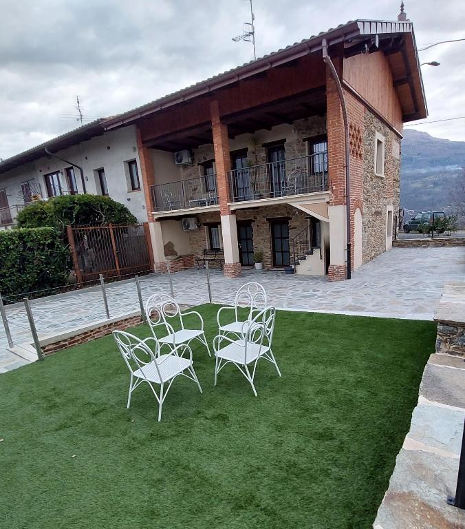 a group of chairs sitting on a lawn in front of a building at Affittacamere il Gallo Panoramico - Alpine Trekking Stay in Donato