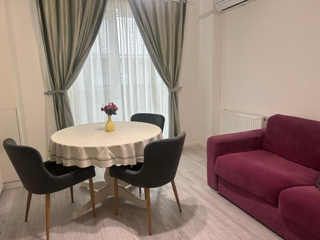 a living room with a table and a purple couch at Cozy Appartament in Floreşti