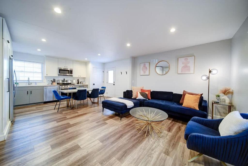 a living room with a blue couch and a table at Stylish 4BR Home - Modern & Bright Interior in Charlotte