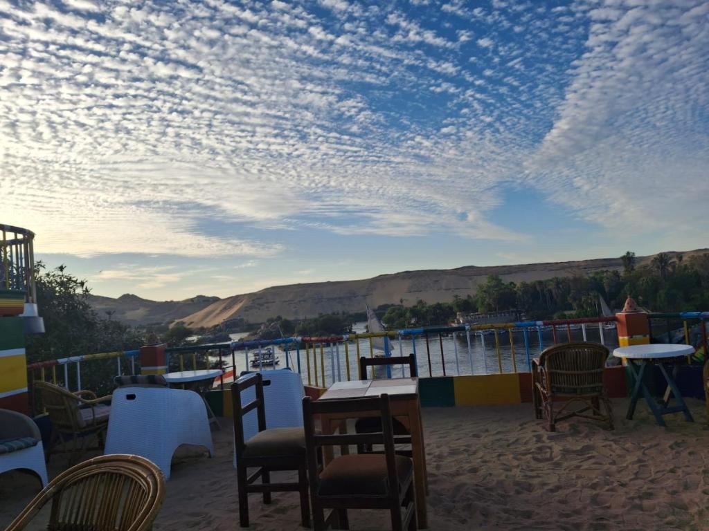 a patio with tables and chairs under a cloudy sky at El Prince Guesthouse in Aswan