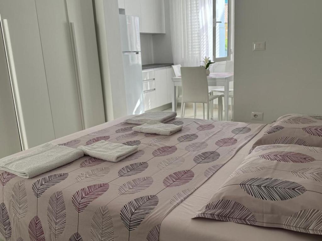 een slaapkamer met een bed met twee handdoeken erop bij ApartHotel Sea & Back view studios in Durrës