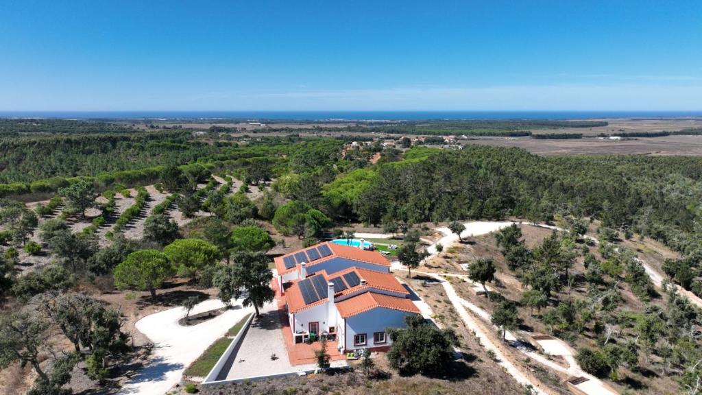 una vista aerea di una casa con l'oceano sullo sfondo di Monte da Silveira a São Teotónio
