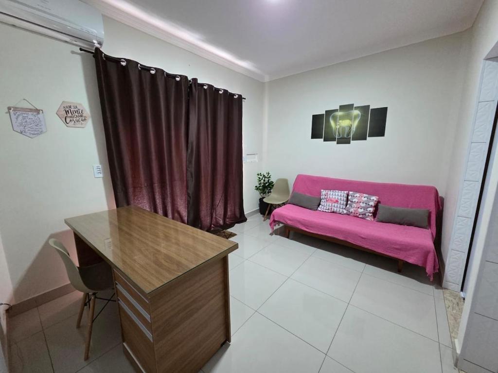 - un salon avec un canapé rose dans l'établissement Aconchego Perfeito em São Pedro SP, à São Pedro