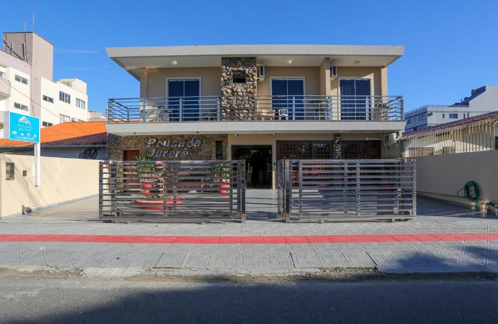 a building with a gate on the side of a street at POUSADA JURERE in Florianópolis