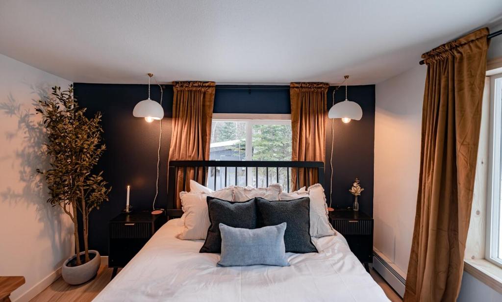 una camera da letto con un letto con cuscini e una finestra di Barrel sauna & Northern lights getaway a Wasilla