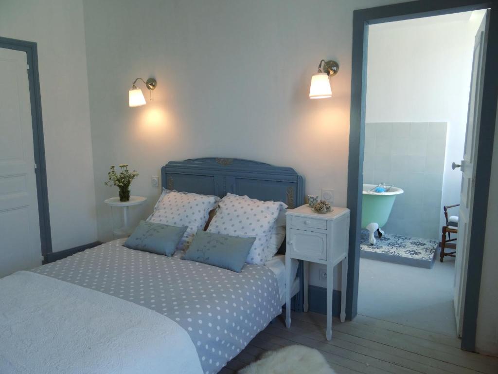a bedroom with a bed and a bathroom with a sink at Les Viviers Maison d'hôtes B&B in Puiseaux