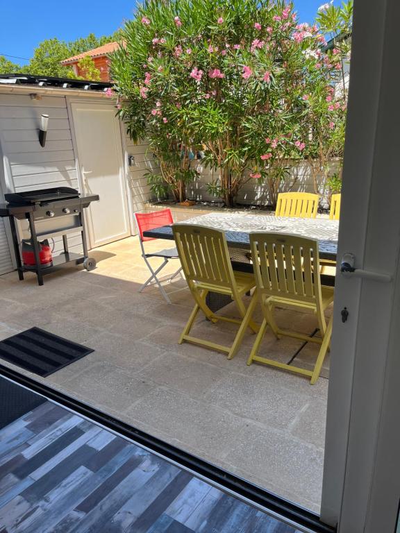 een patio met 2 stoelen, een tafel en een piano bij Villa Josèphe in Capbreton