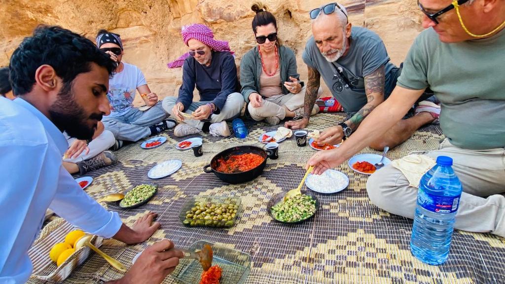 een groep mensen die op de grond eten bij Wadi Rum Karolina Bubbles camp in Wadi Rum