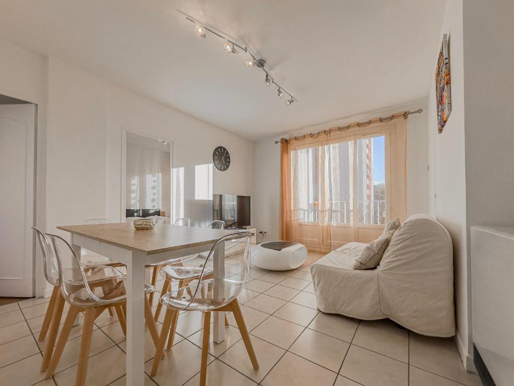 a living room with a table and a couch at Le 19 Lavigne - Parking in Saint-Martin-dʼHères