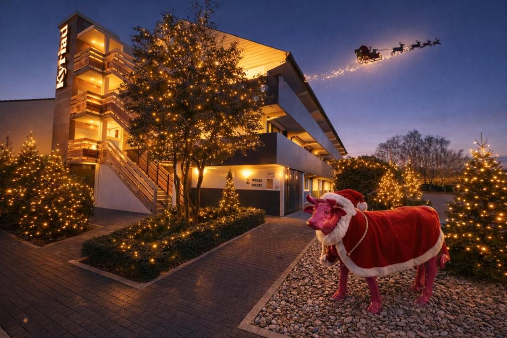 Een kerstmanbeeld voor een huis met kerstverlichting. bij Kyriad Lisieux in Lisieux