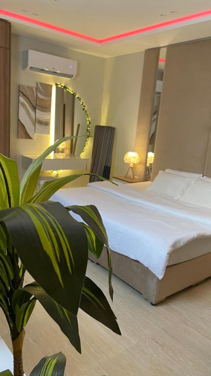 a bedroom with a large bed and a potted plant at Mfj Marbella Stay دخول ذاتي بموقف خاص وإطلالة مسبح in Al Khobar